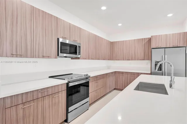 a kitchen with stainless steel appliances granite countertop a stove a sink and a microwave