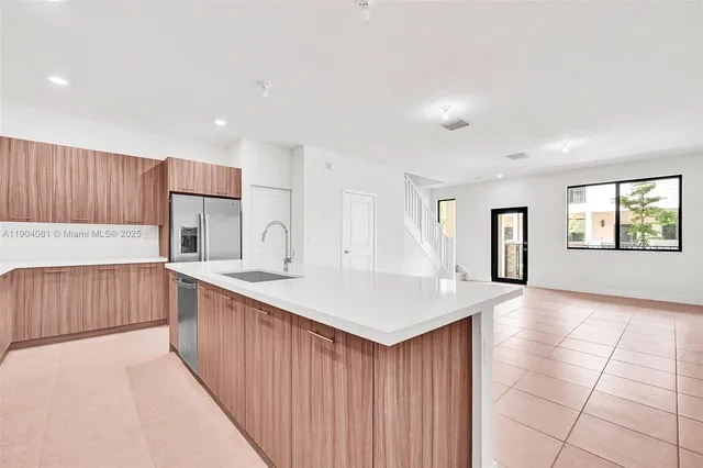a view of kitchen with stainless steel appliances granite countertop a sink dishwasher and a refrigerator with wooden floor