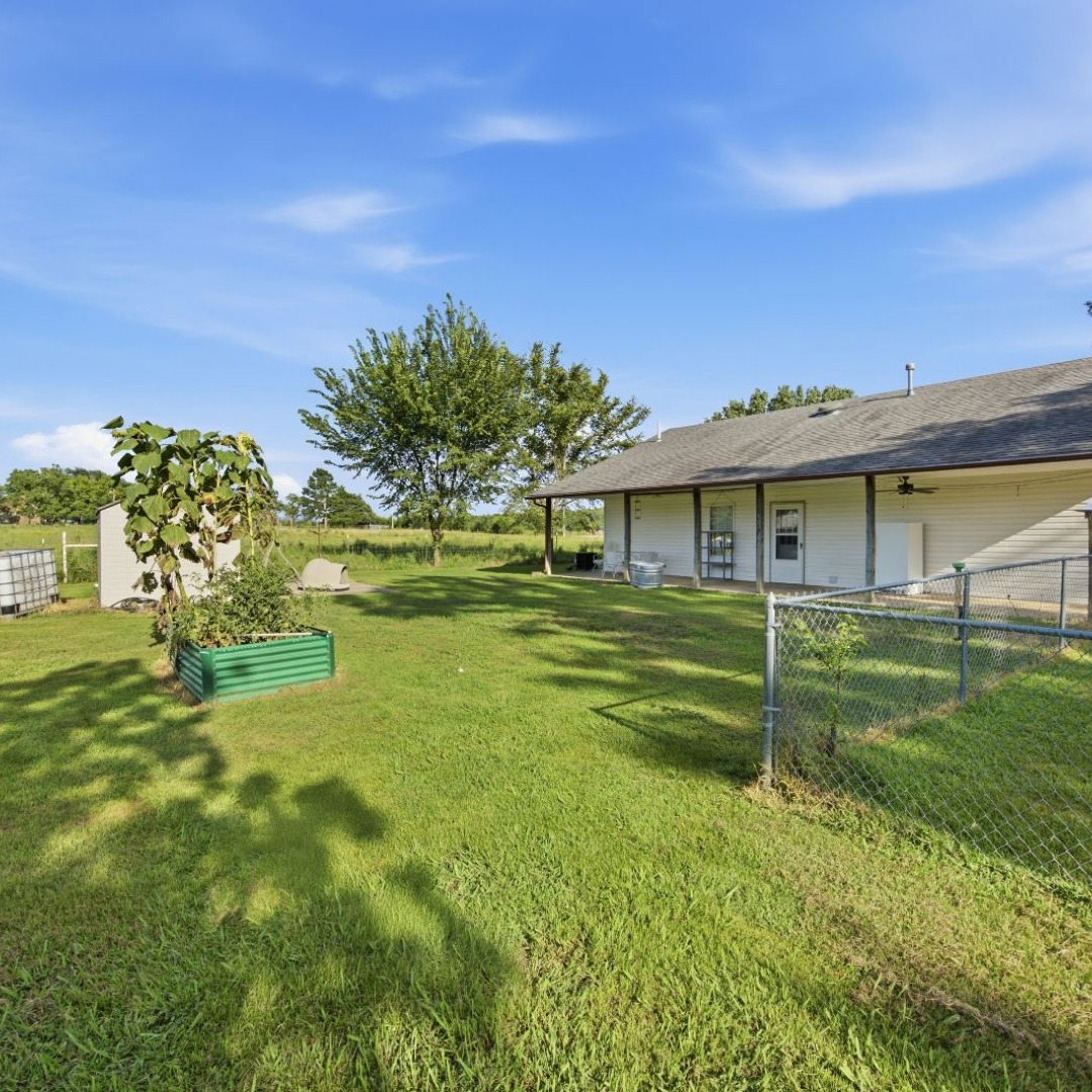 2696 Russellville Road Quinton, OK 74561 - Photo 35 of 40 Expansive rear yard featuring green lawn and a visible chain-link fence to allow your kids or dogs to play