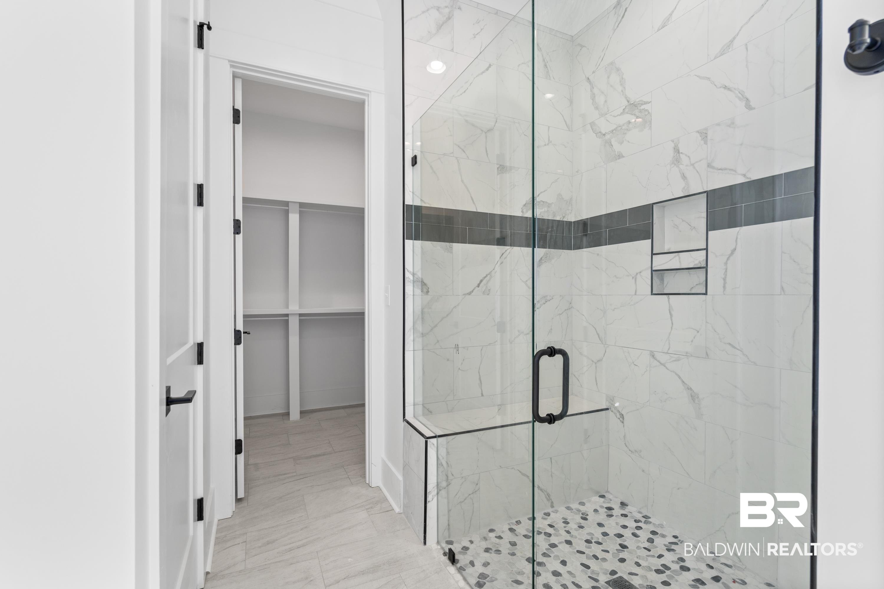 30650 Ono N Loop West Orange Beach, AL 36561 - Photo 18 of 38 Full bathroom featuring a marble finish shower, a spacious closet, and marble look tiles