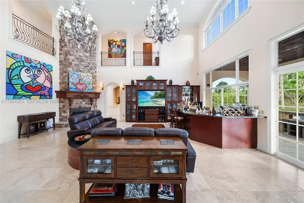 a living room with furniture a fireplace and a chandelier