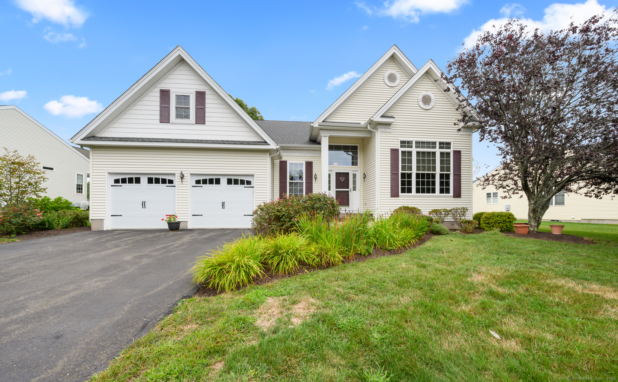 a view of a white house with yard and plants