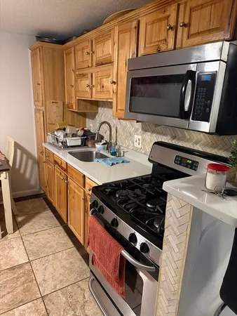 a kitchen with stainless steel appliances a stove a sink and a microwave