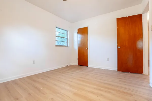 a view of an empty room with wooden floor