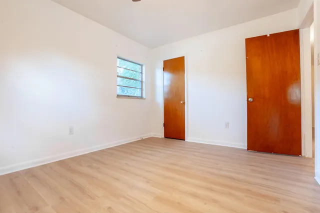 a view of an empty room with wooden floor
