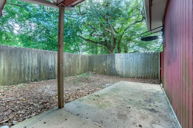 a backyard of a house with a trees and wooden fence