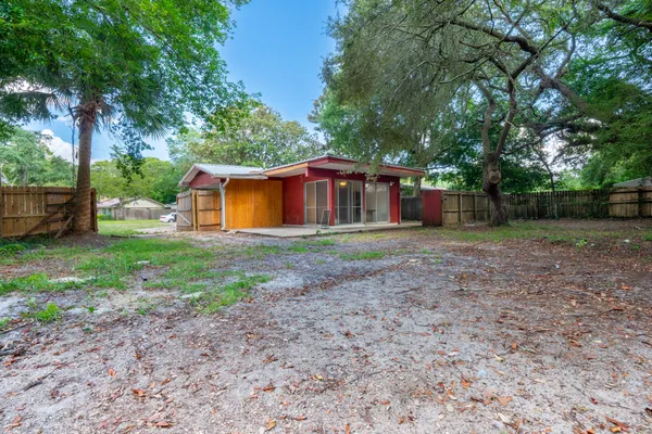 a view of a house with backyard and trees