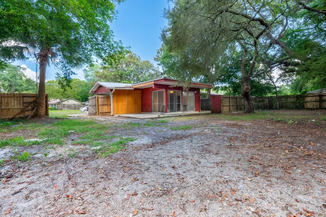 a view of a house with backyard and trees