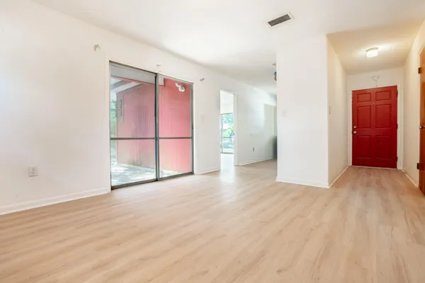 a view of an empty room with wooden floor