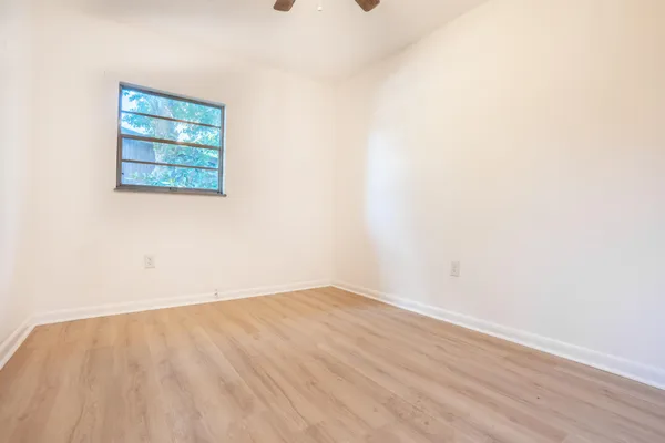 a view of a small space with wooden floor and a window
