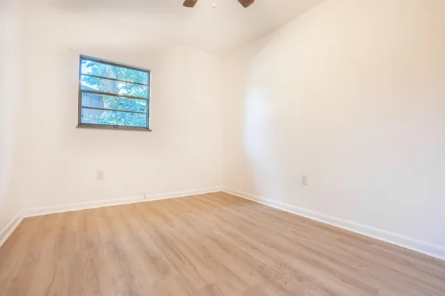 a view of a small space with wooden floor and a window