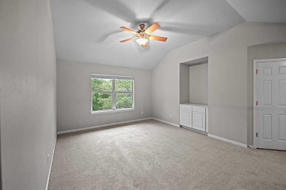 2823 Lantana Ridge Drive Austin, TX 78732 - Photo 17 of 34 an empty room with windows and fan