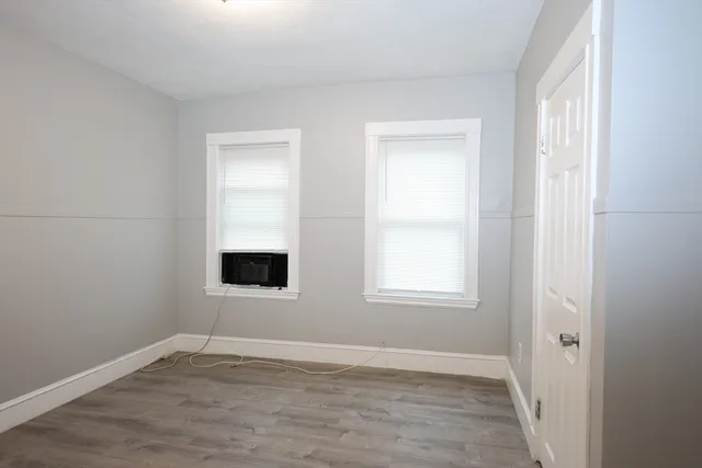an empty room with a window and wooden floor
