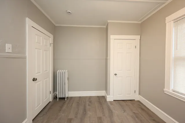 an empty room with wooden floor and a window