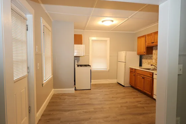 a view of a kitchen with a sink and refrigerator