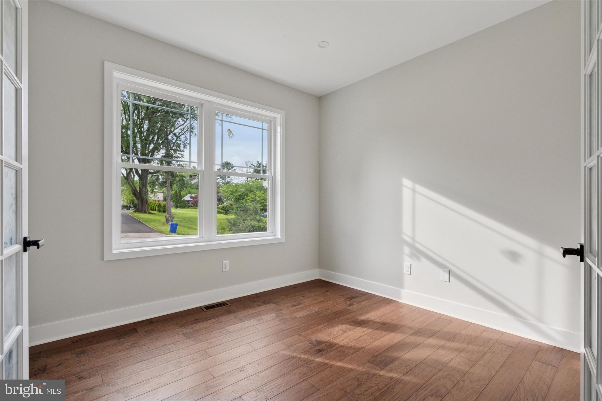 721 Walden Road Cheltenham, PA 19012 - Photo 3 of 25 an empty room with wooden floor and windows
