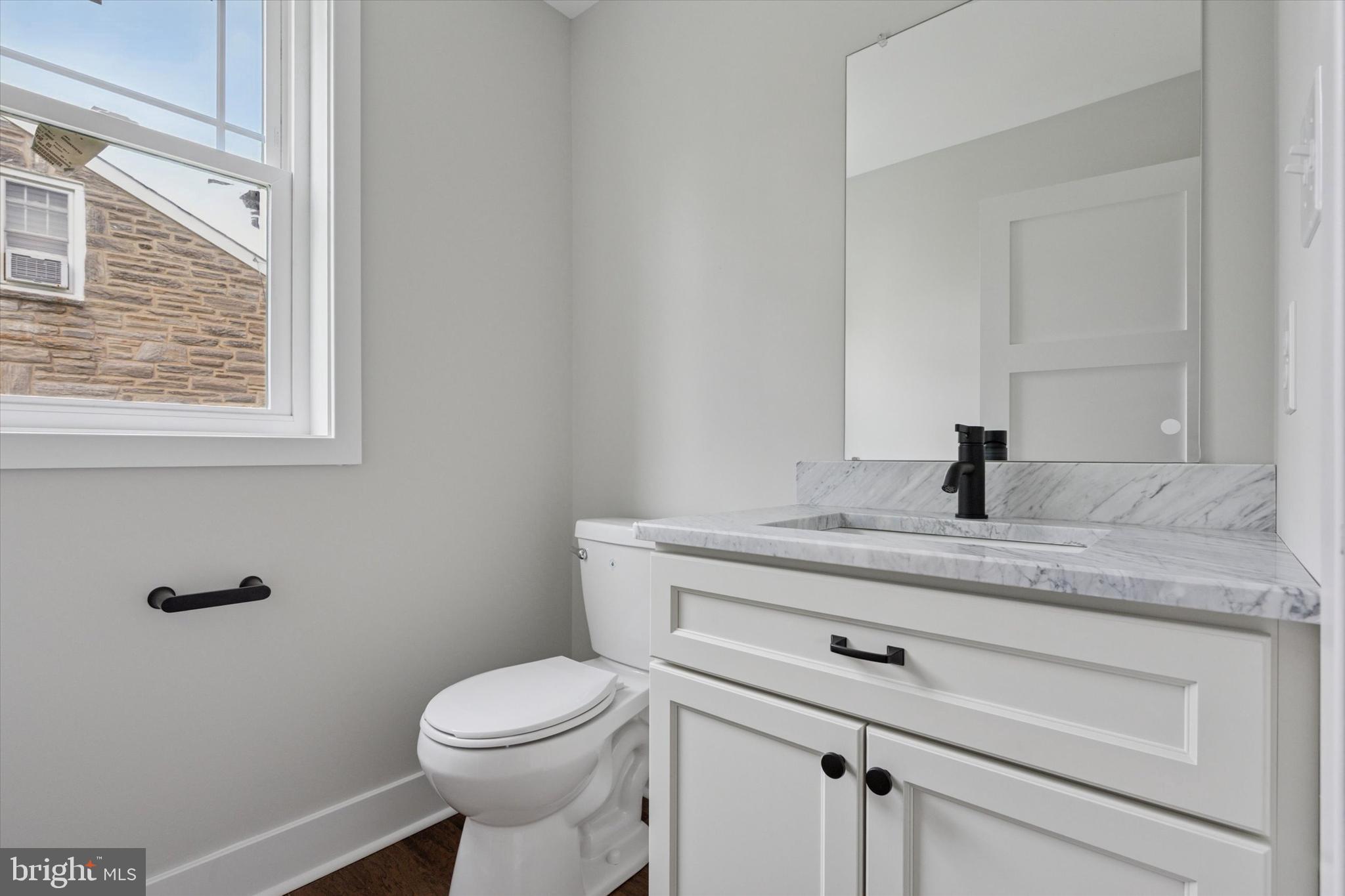 721 Walden Road Cheltenham, PA 19012 - Photo 4 of 25 a bathroom with a granite countertop toilet sink and mirror