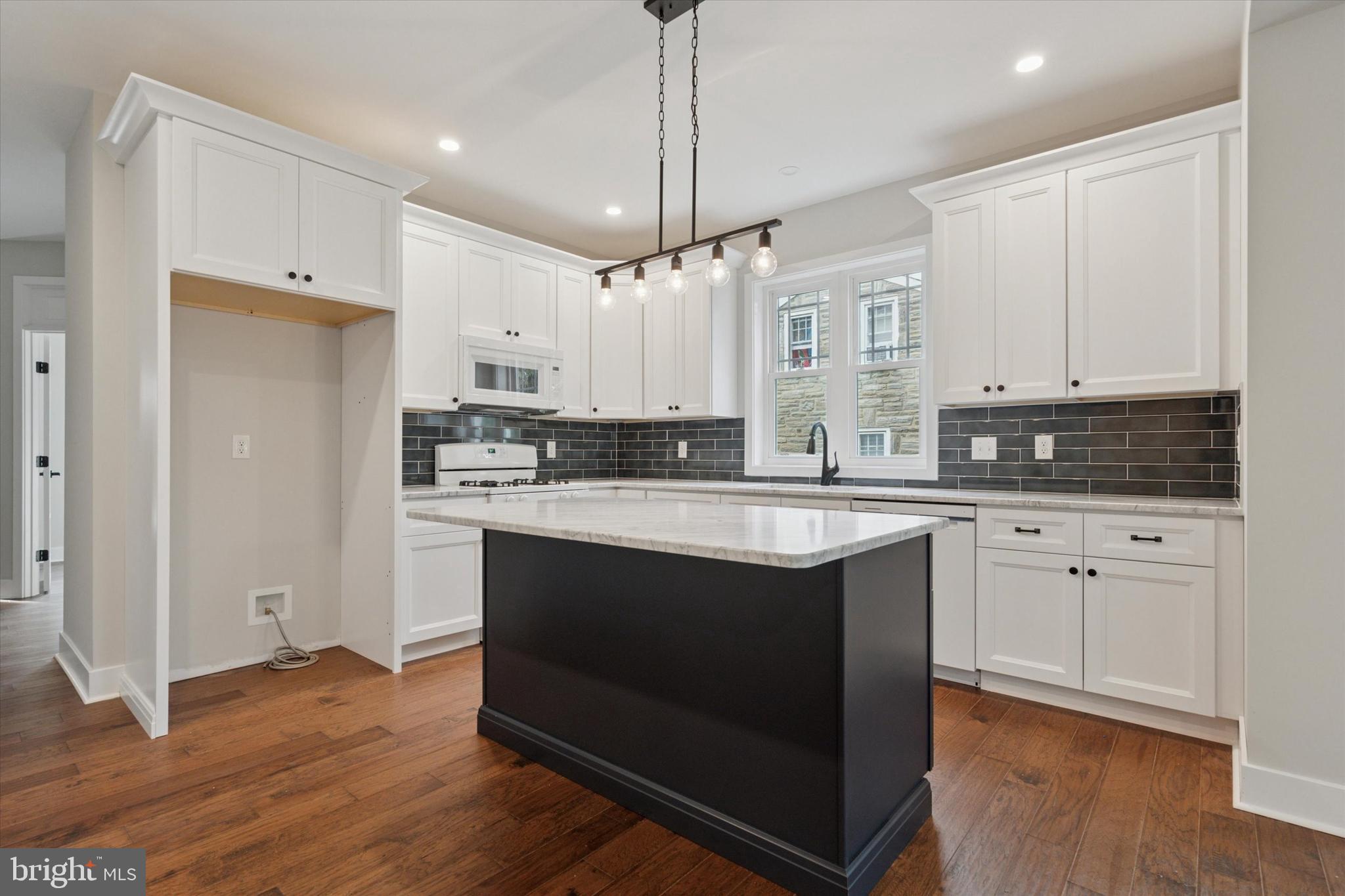 721 Walden Road Cheltenham, PA 19012 - Photo 8 of 25 a kitchen with stainless steel appliances granite countertop a stove a sink and white cabinets with wooden floor