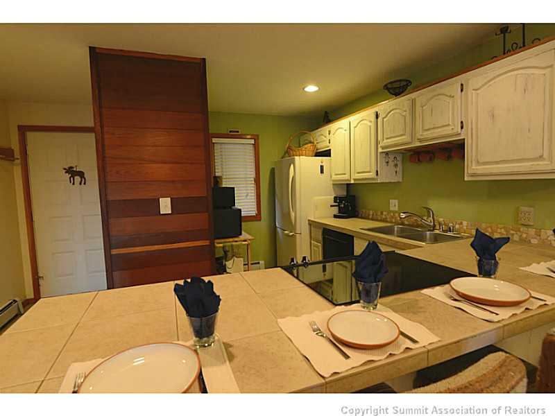 9460 Ryan Gulch Road, Unit 82 Silverthorne, CO 80498 - Photo 7 of 25 Kitchen. Extra seating for guests at the extended bar. New range, dishwasher and refrigerator. Custom tile counters and back splash.