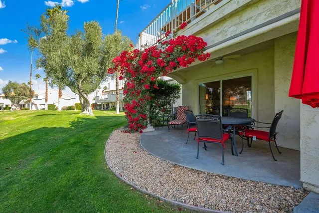 a view of a house with backyard and sitting area
