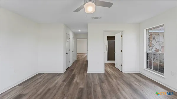 a view of a hallway with wooden floor and chandelier