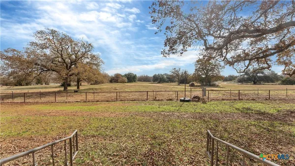 a view of a yard with wooden fence