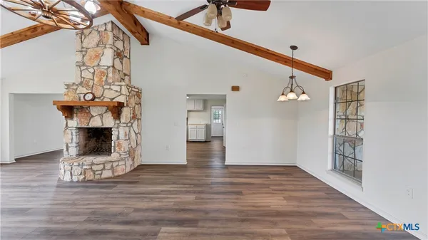 a view of a livingroom with wooden floor and a fireplace