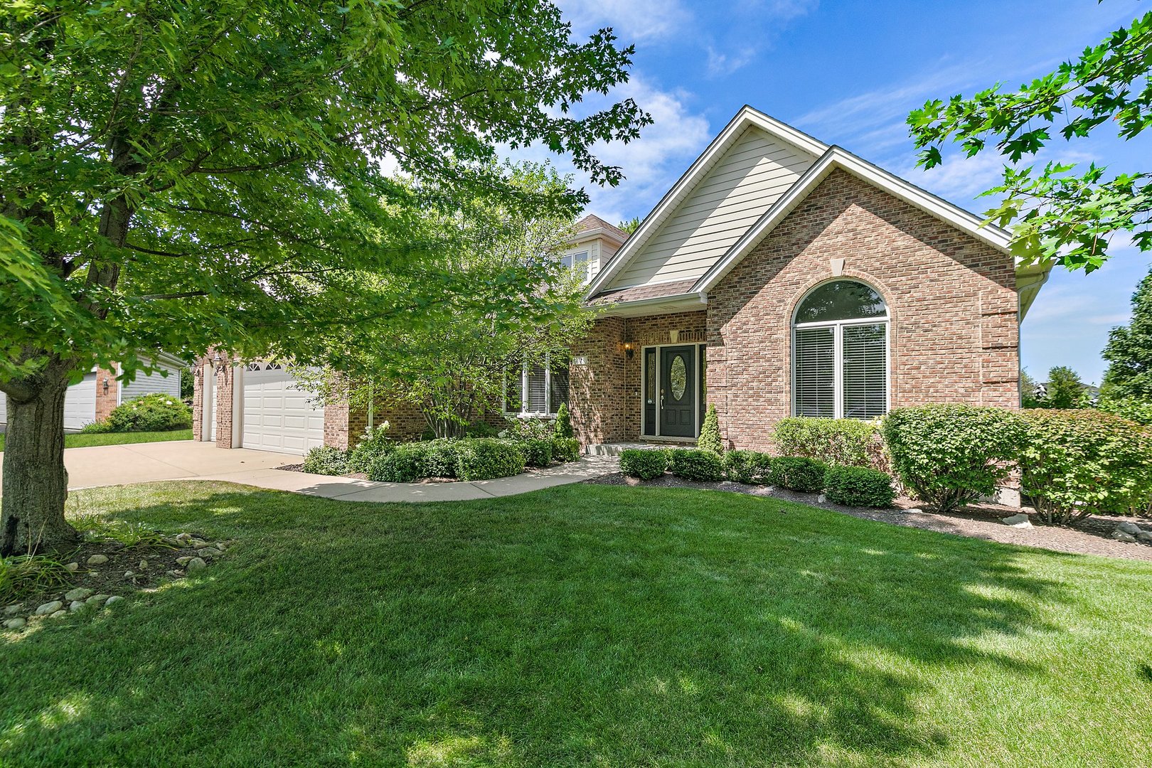 a front view of a house with a yard and trees