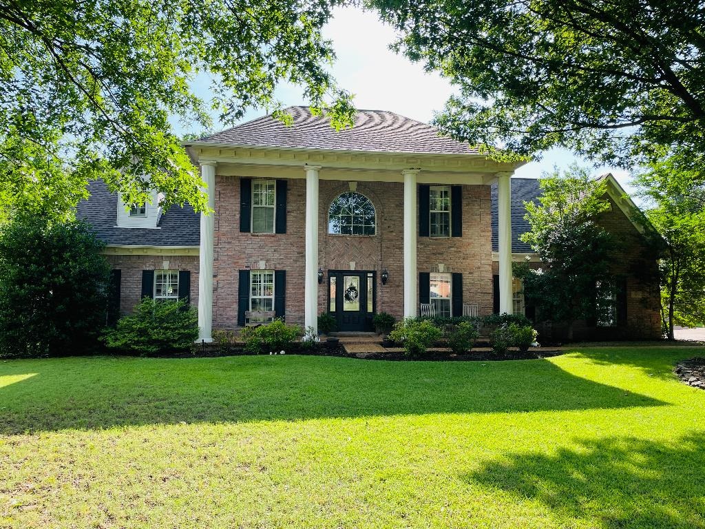 a front view of a brick house with a yard