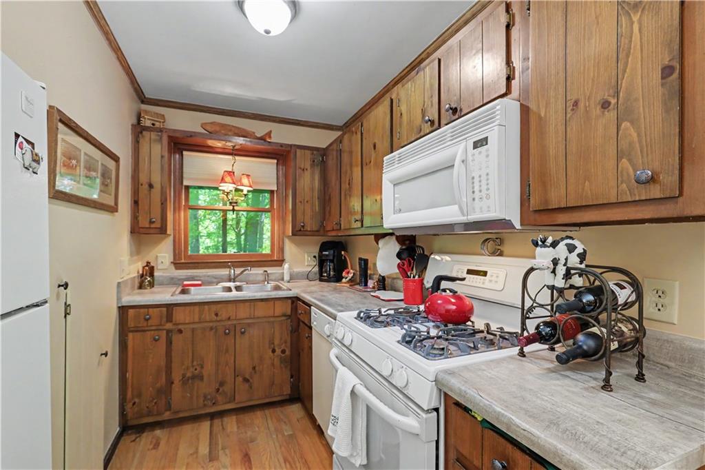 102 Moses Road Rabun Gap, GA 30568 - Photo 13 of 40 a kitchen with a sink stove and cabinets