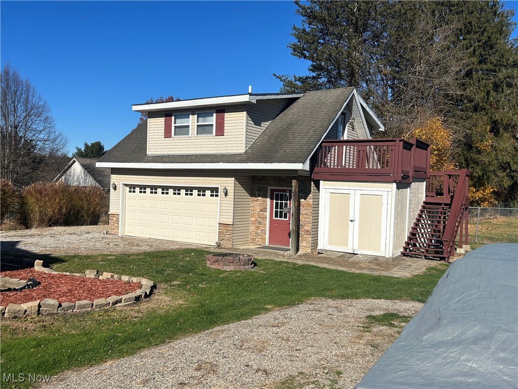 150 West Athens Road Roseville, OH 43777 - Photo 11 of 17 View of front of property featuring stairs, roof with shingles, stone siding, driveway, and a deck