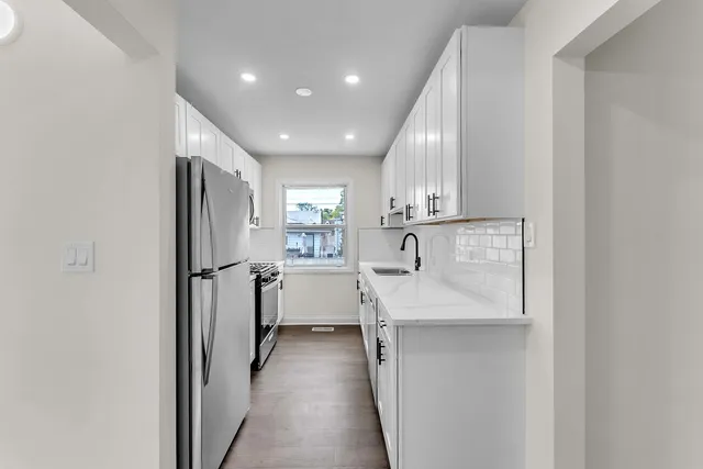 a kitchen with kitchen island a sink appliances and cabinets