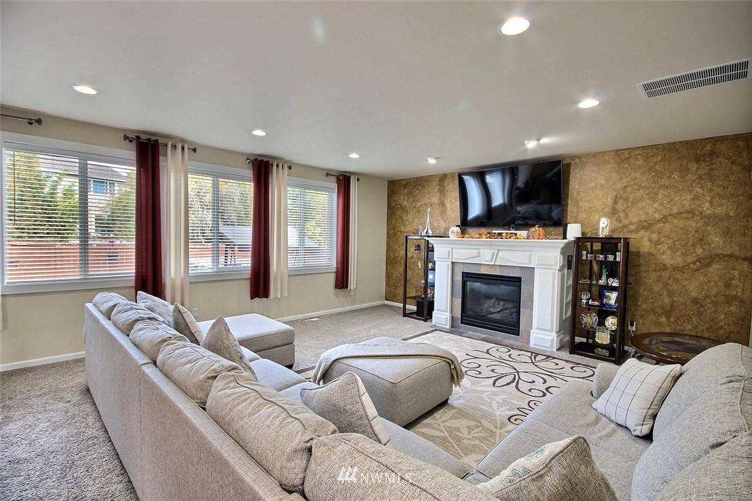 12946 Southeast 216th Place Kent, WA 98031 - Photo 14 of 39 a living room with furniture a fireplace and a flat screen tv