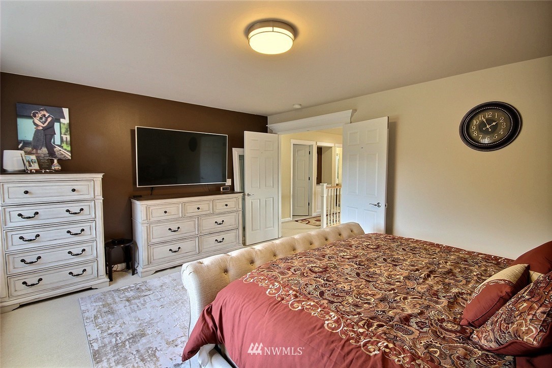 12946 Southeast 216th Place Kent, WA 98031 - Photo 22 of 39 a bedroom with a bed and a flat screen tv