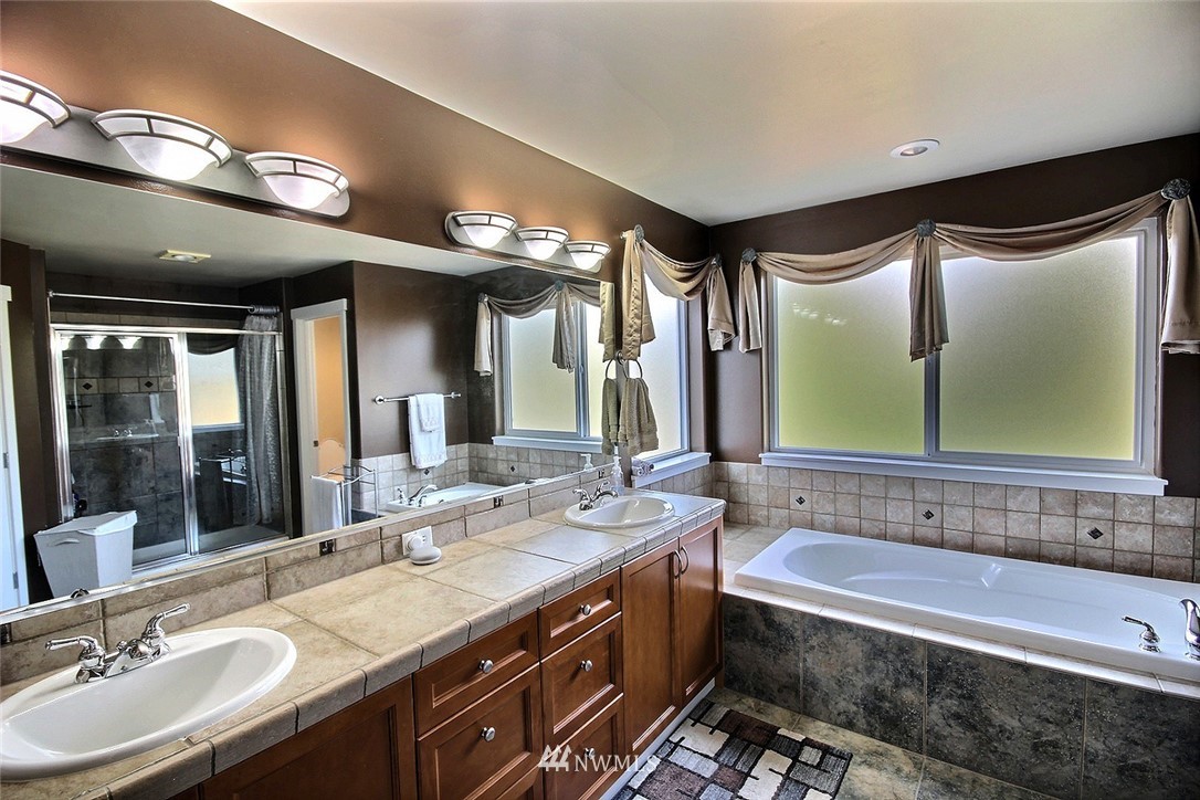 12946 Southeast 216th Place Kent, WA 98031 - Photo 23 of 39 a bathroom with a granite countertop sink mirror and bathtub