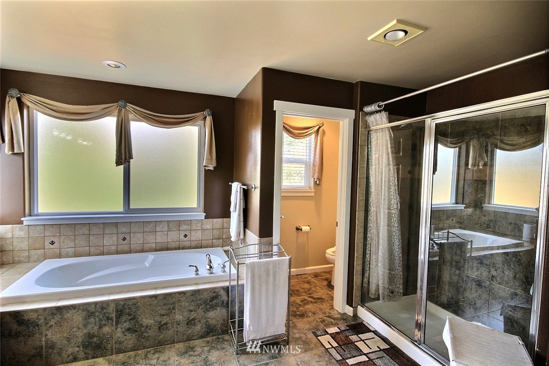 12946 Southeast 216th Place Kent, WA 98031 - Photo 24 of 39 a bathroom with a bathtub and a shower