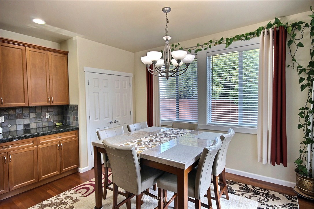 12946 Southeast 216th Place Kent, WA 98031 - Photo 8 of 39 a dining room filled chandelier and wooden floor