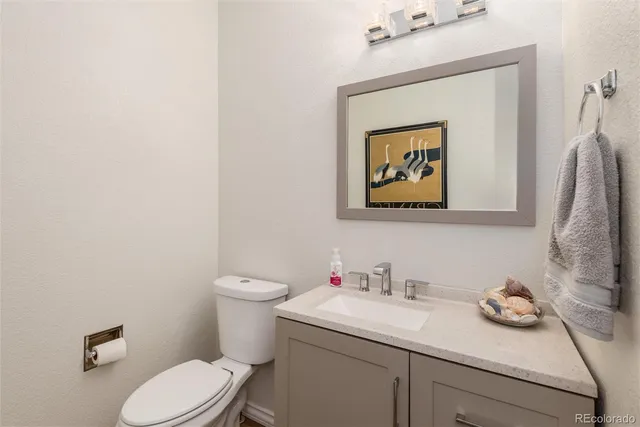a bathroom with a granite countertop sink and a toilet