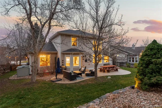 a front view of a house with garden and trees