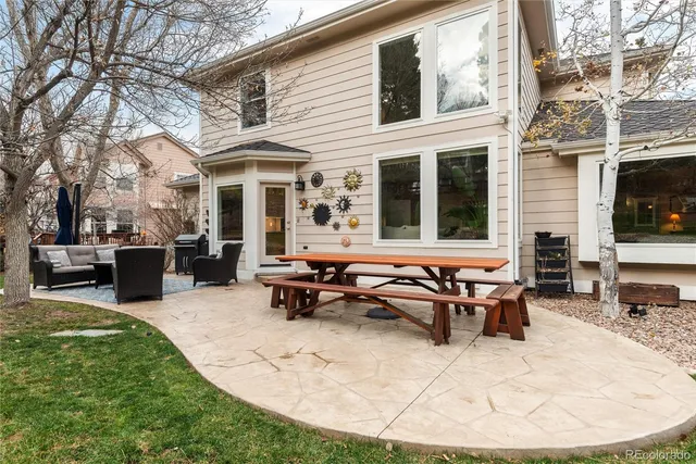 a view of a patio with table and chairs with wooden floor and fence