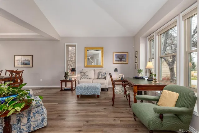 a living room with furniture wooden floor and a large window