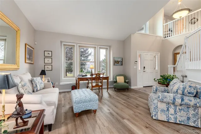 a living room with furniture large window and wooden floor