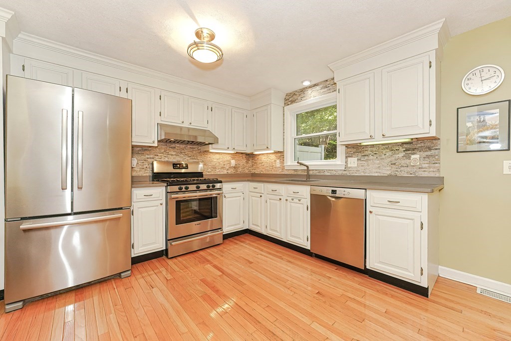 9 Apple Ridge Road, Unit 4 Maynard, MA 01754 - Photo 11 of 33 a kitchen with stainless steel appliances granite countertop a refrigerator a stove a sink and white cabinets with wooden floor