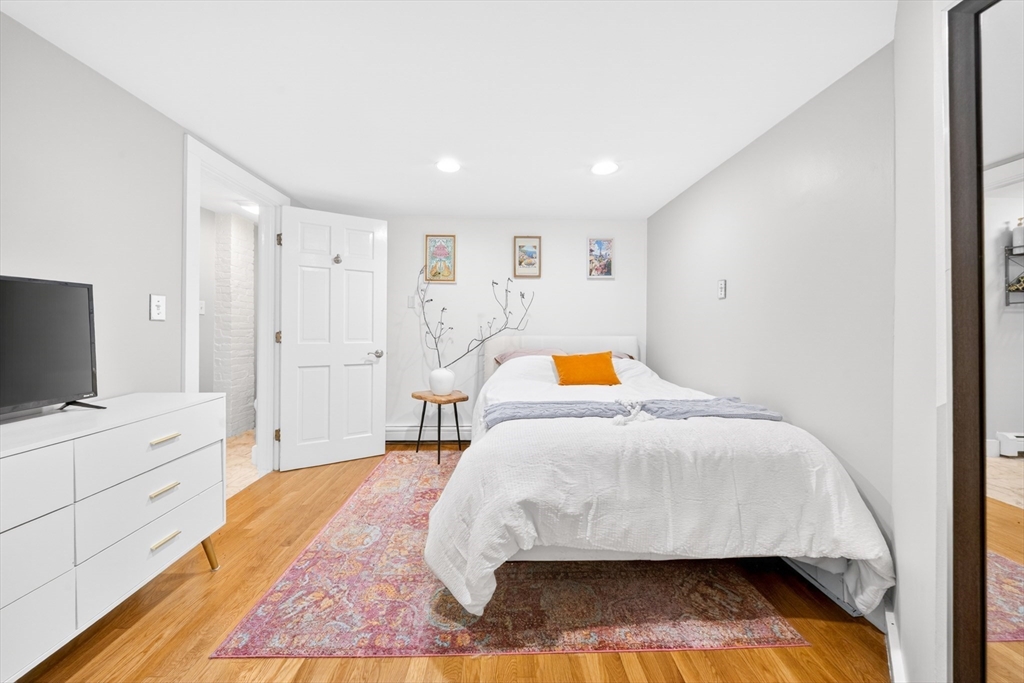 352 Tappan Street, Unit 1 Brookline, MA 02445 - Photo 24 of 42 a bedroom with a bed and a flat tv screen on dresser