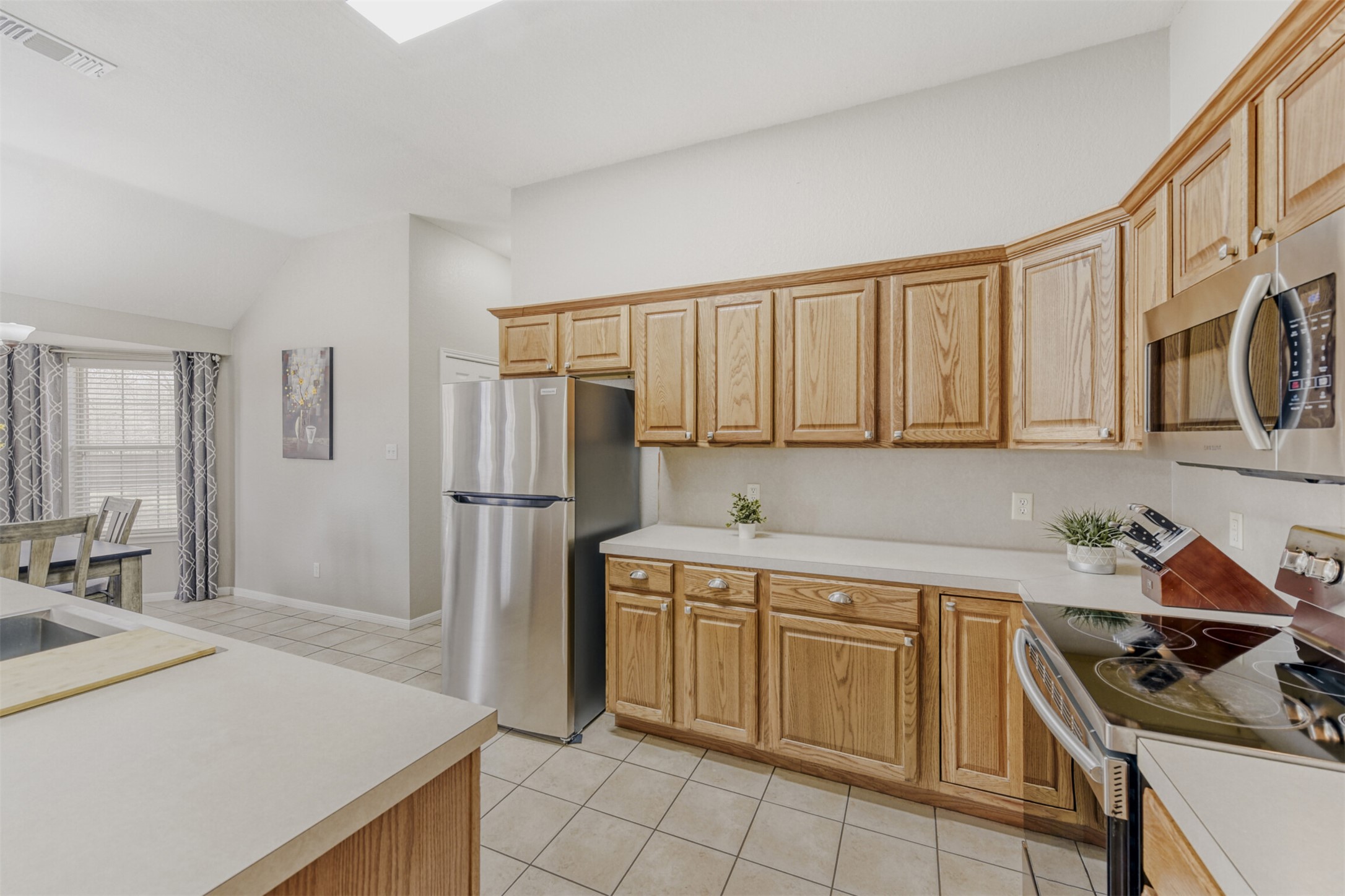 104 Spring Branch Bastrop, TX 78602 - Photo 18 of 32 Kitchen with stainless steel appliances, light countertops, light tile patterned floors, and lofted ceiling