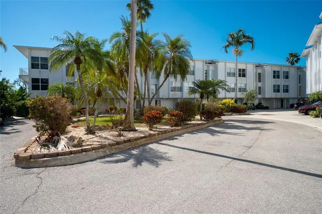 a view of a house with small yard and palm trees