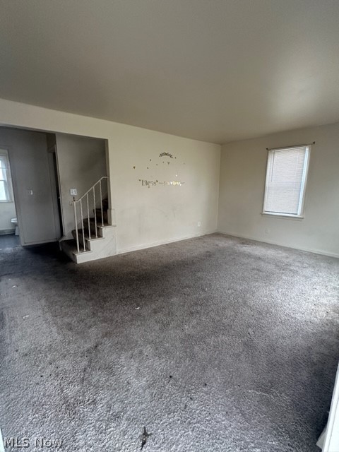 21400 Watson Road Maple Heights, OH 44137 - Photo 2 of 24 Empty room featuring dark carpet and a healthy amount of sunlight