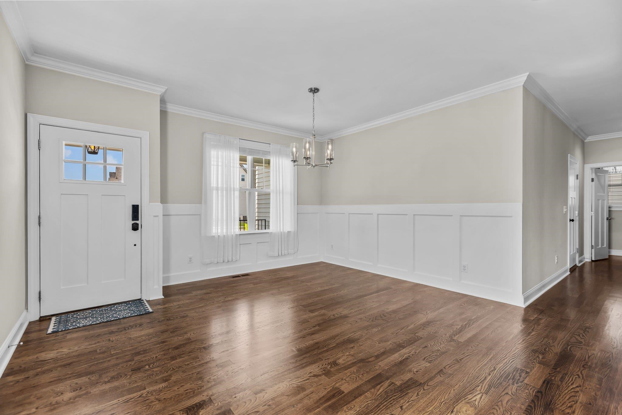 357 Marshcroft Way Rolesville, NC 27571 - Photo 6 of 52 an empty room with wooden floor chandelier and windows
