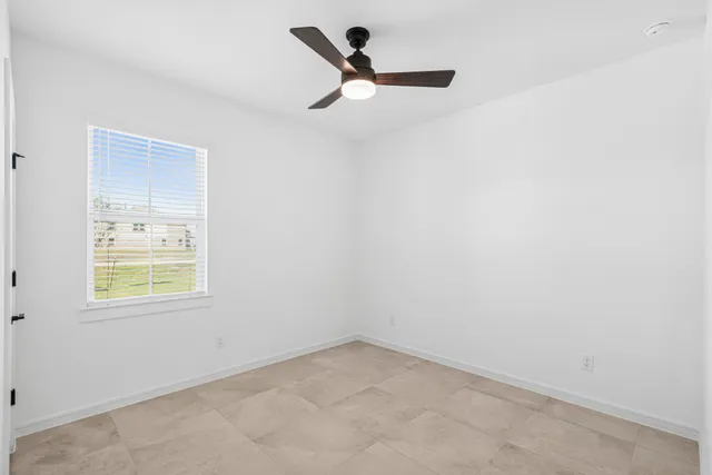 a view of an empty room with closet and a window