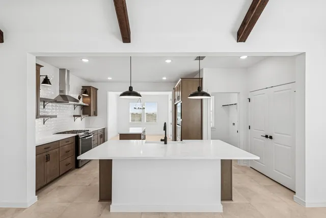 an empty room that has a window and kitchen view